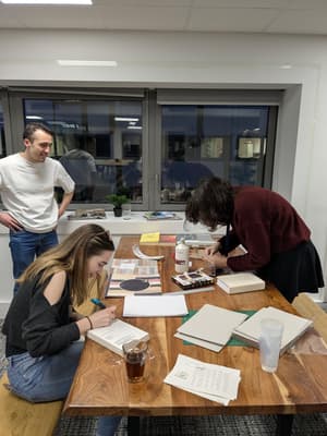 Atelier de reliure avec outils et matériaux sur une table de travail.